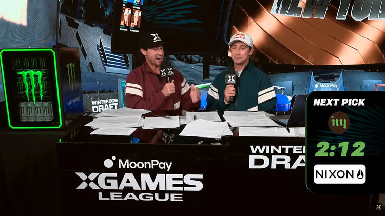 The presenters at the X Games League Winter Draft sitting in their booth while a Nixon branded clock ticks down the time between picks.