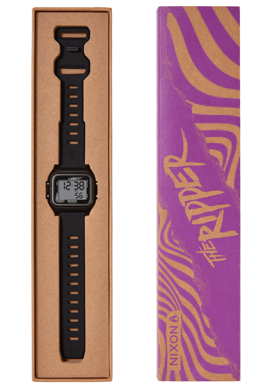A black digital watch with a rubber strap is displayed in a brown cardboard box next to its purple and gold striped packaging with "THE RIPPER" written on it.